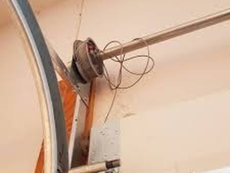 Loose lift cable at a drum above a door