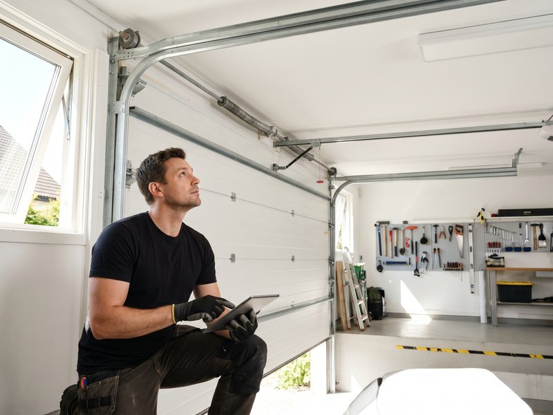 Technician holding a tablet while looking toward a raised door