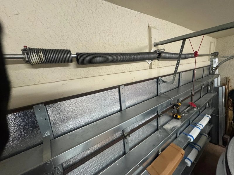 Two torsion springs on a shaft above insulated steel door sections
